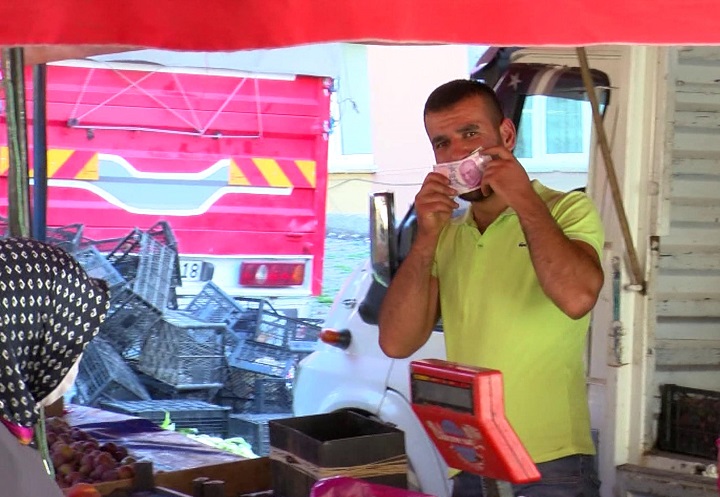 Görüntülendiğini fark etti, parayı maske olarak kullandı
