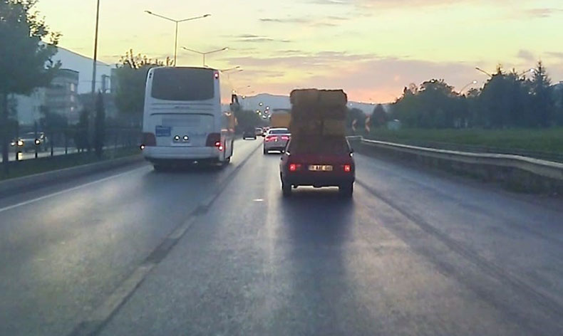Trafikte otomobil üzerinde saman balyaları taşıdı