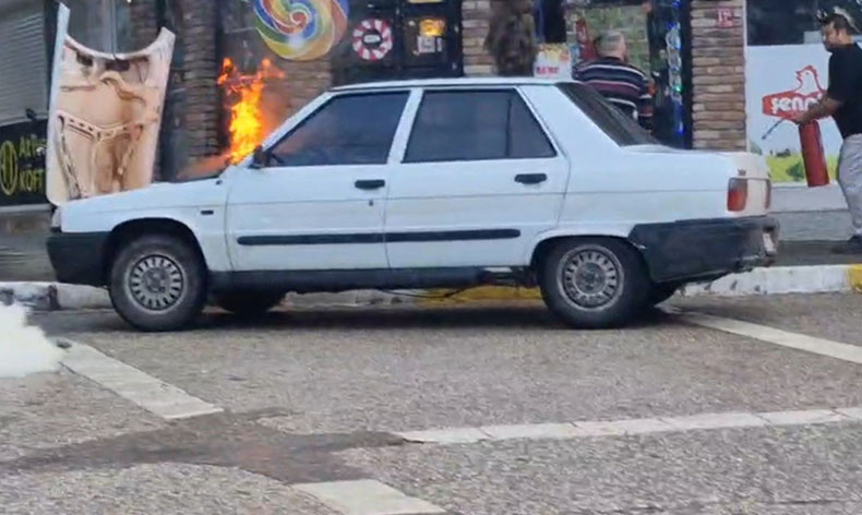 Alev alan otomobili esnaf söndürdü