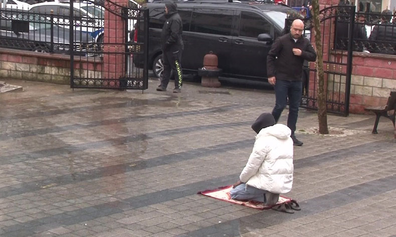 Yağmura rağmen namazına devam etti